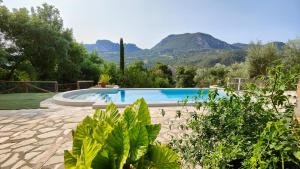 a swimming pool in a garden with mountains in the background at Vivienda Turística El Acebuchal in Ubrique