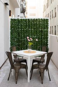 une table blanche avec des chaises et un vase avec des fleurs. dans l'établissement Luxury Apartment In The Prime Hollywood Location, à Los Angeles