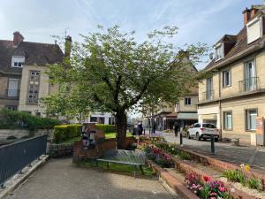 un parc avec un banc, un arbre et des fleurs dans l'établissement Pause En Seine- Appartement en duplex, à Caudebec-en-Caux