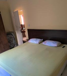 a bedroom with a large white bed with two pillows at Casa próximo da praia in Prado +16 photos