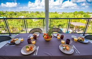 a purple table with plates of food on a balcony at Zandoli Exotic Résidence in Sainte-Anne