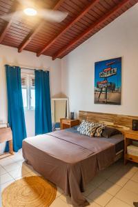 1 dormitorio con 1 cama grande y cortinas azules en Zandoli Exotic Résidence, en Sainte-Anne