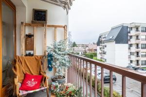- un balcon avec un oreiller rouge et une plante dans l'établissement Bohemian Cocon Annecy - spacieux T2 - balcon avec vue dégagée - place de parking, à Meythet