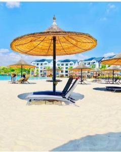 a beach with a yellow umbrella and chairs on the sand at Serenity @The Blyde Crystal Lagoon in Pretoria