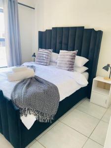 1 dormitorio con 1 cama grande y cabecero azul en Serenity @The Blyde Crystal Lagoon, en Pretoria