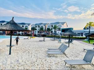 a person walking on a beach with chairs and umbrellas at Serenity @The Blyde Crystal Lagoon in Pretoria