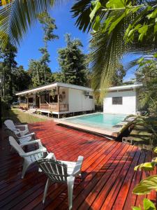 a deck with two chairs and a swimming pool at Casa Ackee in Talamanca