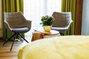 Deux chaises et un vase avec des fleurs sur une table dans l'établissement Hotel-Restaurant Bellevue, à Ruhpolding