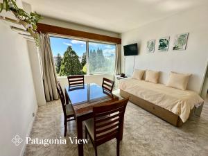 Un dormitorio con una cama y una mesa y sillas. en Patagonia View, en San Carlos de Bariloche