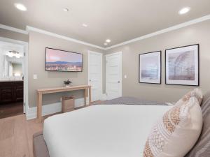 a bedroom with a white bed and a desk at Kennebeck Oasis - Private Patio, Steps 2 Sand & AC in San Diego