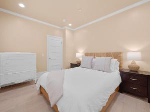 a white bedroom with a large bed and a dresser at Kennebeck Oasis - Private Patio, Steps 2 Sand & AC in San Diego