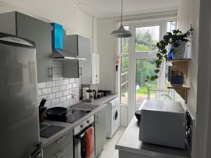 a white kitchen with a sink and a window at Reservoir Retreat in Birmingham