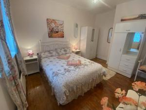 a bedroom with a bed and two tables and a refrigerator at Sunrise Cottage in Killybegs