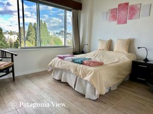 Un dormitorio con una cama y una ventana grande. en Patagonia View, en San Carlos de Bariloche