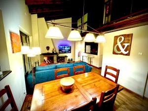 a living room with a wooden table and a blue couch at Ático duplex a pie de pistas de esquí in La Molina