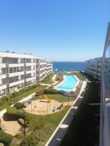 einen Blick vom Balkon eines Apartmenthauses mit Spielplatz in der Unterkunft ACOGEDOR Dpto FRENTE AL MAR EN EL TABO in El Tabo