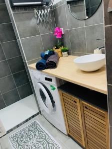 a bathroom with a washing machine and a sink at "Chez Grâce" in Saintes