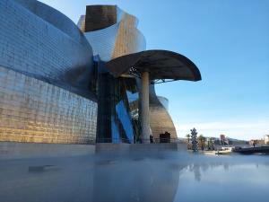un gran edificio de cristal con una cúpula sobre el agua en bilbao center apt 90´s PARKING, en Bilbao