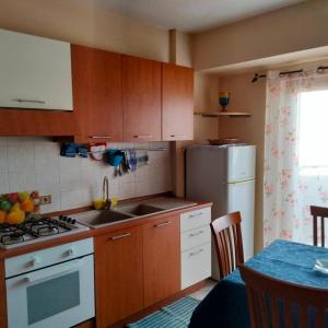 a kitchen with wooden cabinets and a sink and a refrigerator at Daniele's home close to Rome in Pomezia