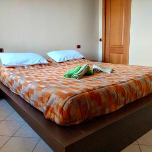a bed with an orange and orange comforter with two bags on it at Daniele's home close to Rome in Pomezia