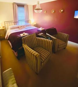 a bedroom with a bed and two chairs and a table at Modern ground floor apartment with free parking very near centre in Ripon