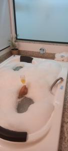uma banheira com um copo de vinho em Pousada da Lua São Pedro em São Pedro