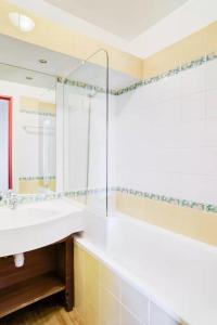 La salle de bains est pourvue d'un lavabo blanc et d'une douche. dans l'établissement Résidence Le Rami Les Coches - La Plagne, à La Plagne Tarentaise