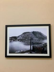 un marco de imagen colgando de una pared con una montaña en Ridi's Comfort Apartment, en Shkodër