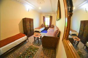 Pokój z 2 łóżkami, kanapą i stołem w obiekcie Fez Experiences w Fezie