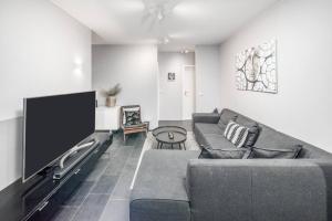 a living room with a couch and a flat screen tv at Kopavogur Cozy Nest (3-bedrooms) in Reykjavík