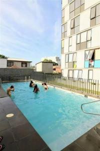 eine Gruppe von Personen, die in einem Schwimmbad schwimmen in der Unterkunft Departamento 2 espacios, 1 pieza in Santiago