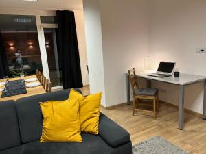 a living room with a couch and a table with a laptop at Apartament Sternicza in Warsaw
