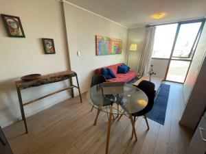 uma sala de estar com um sofá vermelho e uma mesa de vidro em Departamento 2 espacios, 1 pieza em Santiago