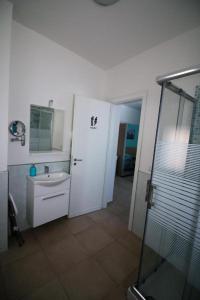 a bathroom with a shower and a sink and a mirror at La Rosatea Rooms in Monreale