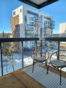 2 sillas en un balcón con vistas a un edificio en City Island Studio Apartment, 4 beds, free street parking with parking disc, bus stop 200m, en Helsinki