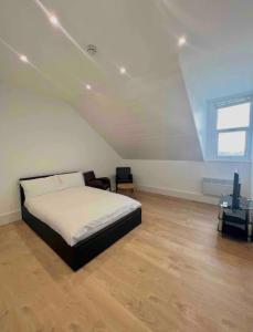Habitación blanca con cama y TV. en New modern studio flat, en Brighton & Hove