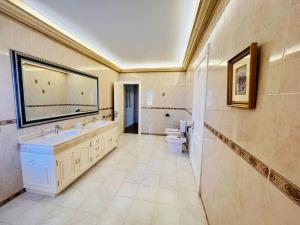 a large bathroom with a sink and a toilet at Kishni, peaceful and luxury suite villa in Arrecife