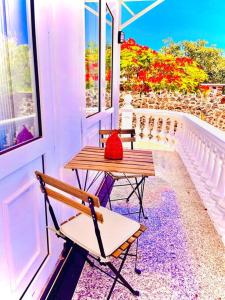a table and chair on a porch with a red bag on it at Kishni, peaceful and luxury suite villa in Arrecife