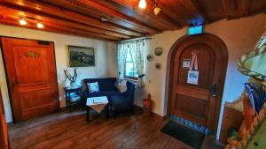 Apartman Tauplitz skiing, hiking, bike, cross country - Haus Sandlweber في Obersdorf: غرفة معيشة مع أريكة زرقاء وباب