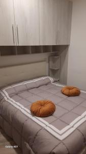 Una cama con dos almohadas marrones encima. en La piccola Noralù, en Grottaferrata