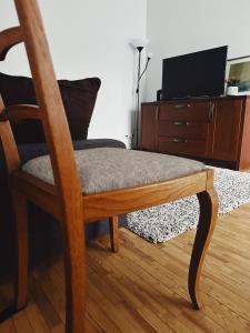 a chair sitting in a living room with a tv at City Center Apartments in Vilnius
