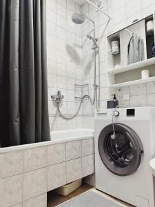 a bathroom with a washing machine and a shower at City Center Apartments in Vilnius