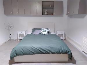 a white bedroom with a bed and two tables at Au soin de la Vie 