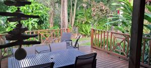 a patio with a table and chairs on a deck at Les Manguiers in Deshaies