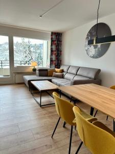 ein Wohnzimmer mit einem Sofa und einem Tisch in der Unterkunft Ferienwohnung Bad Sachsa Harz II in Bad Sachsa