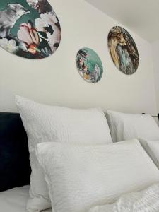 ein weißes Bett mit vier Platten an der Wand in der Unterkunft Ferienwohnung Bad Sachsa Harz II in Bad Sachsa