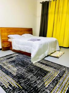 a bedroom with a bed with a rug on the floor at Drew Apartment Tanga in Tanga