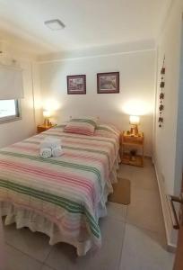 ein Schlafzimmer mit einem großen Bett mit zwei Handtüchern darauf in der Unterkunft Departamento centrico en Posadas in Posadas