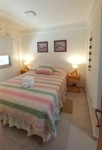 une chambre avec un grand lit avec deux serviettes dessus dans l'établissement Departamento centrico en Posadas, à Posadas