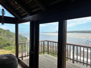 uma vista para a praia a partir de um quarto com janelas em Breede View em Kontiki